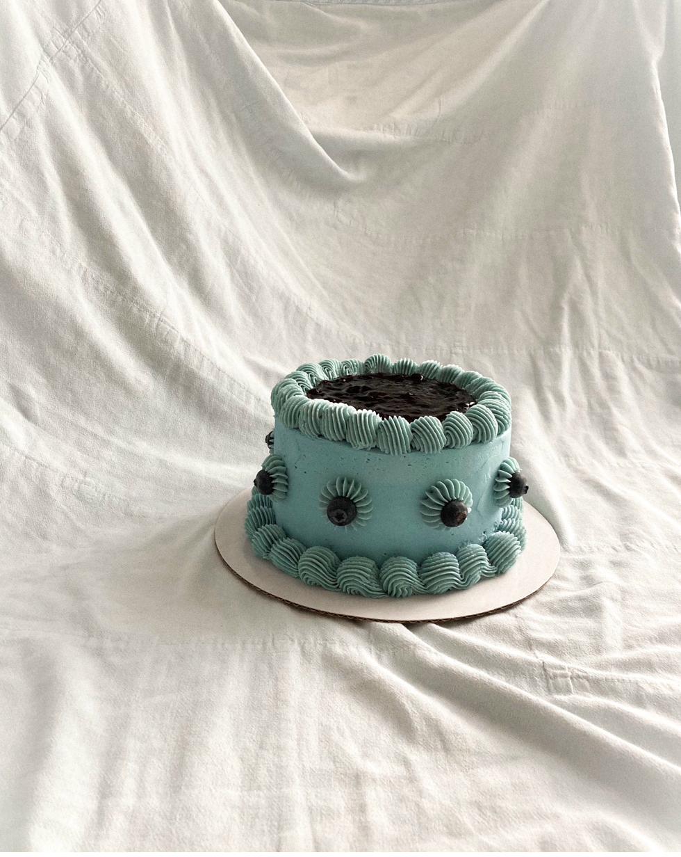 Celebration cake — two-tier vintage style with pink, green and mauve piped ruffles, cherries and dried fruit