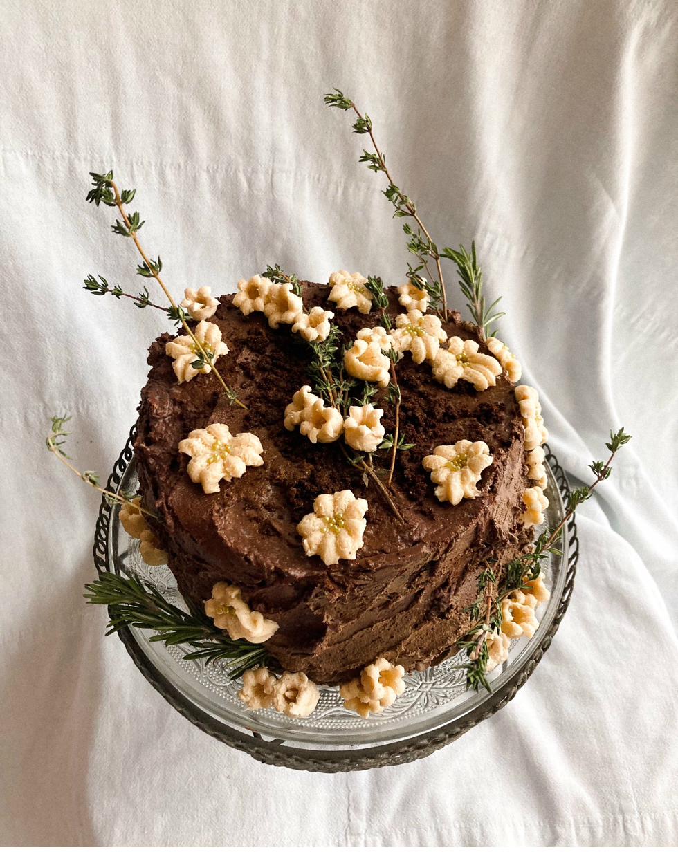 Celebration cake — pink raspberry buttercream with red cherry compote top, piped coral and red details