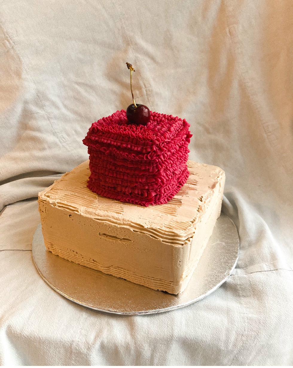 Celebration cake — cream buttercream with red, blue and green piped ribbons and yellow rosettes