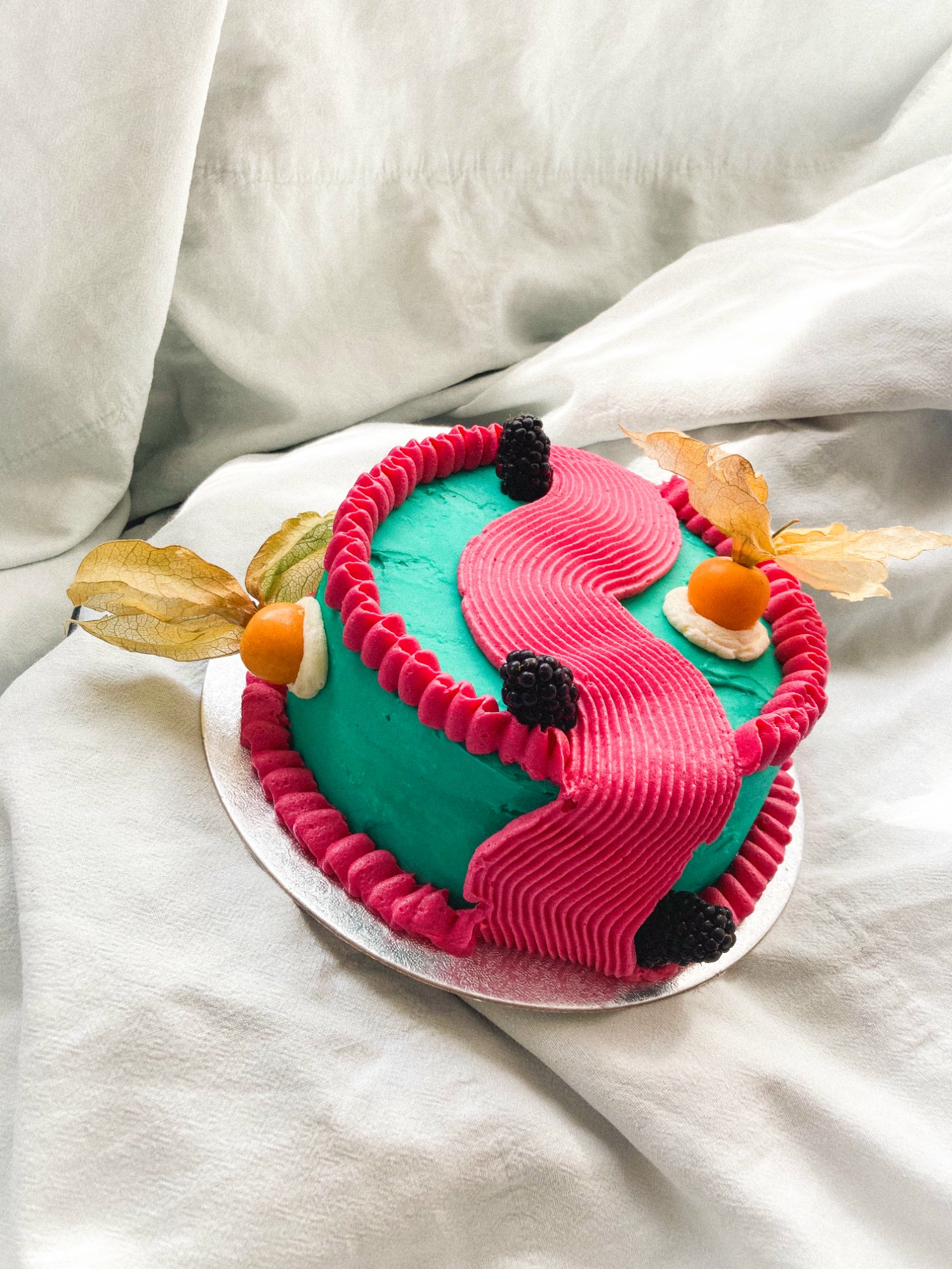 Celebration cake — grey sesame buttercream with physalis, blueberries and piped details