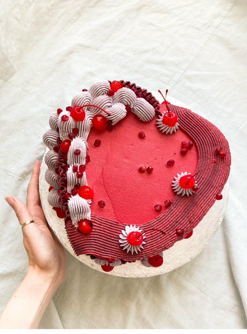 Celebration cake — cream and yellow piped flowers on dark chocolate with fresh rosemary and thyme